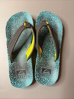 Kid’s Reef Blue & Black Patterned Flip Flops w/ yellow accent. Size: 2